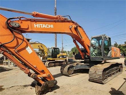 Orange Hitachi excavator on a construction site with clear blue sky.