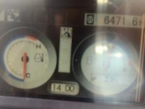 heavy equipment dashboard with speedometer and tachometer, showing mileage and temperature.