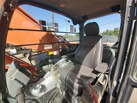 Inside view of a vehicle with a bucket attachment, showing the driver's seat and dashboard  heavy machinery for sale near corona ca by westrax machinery